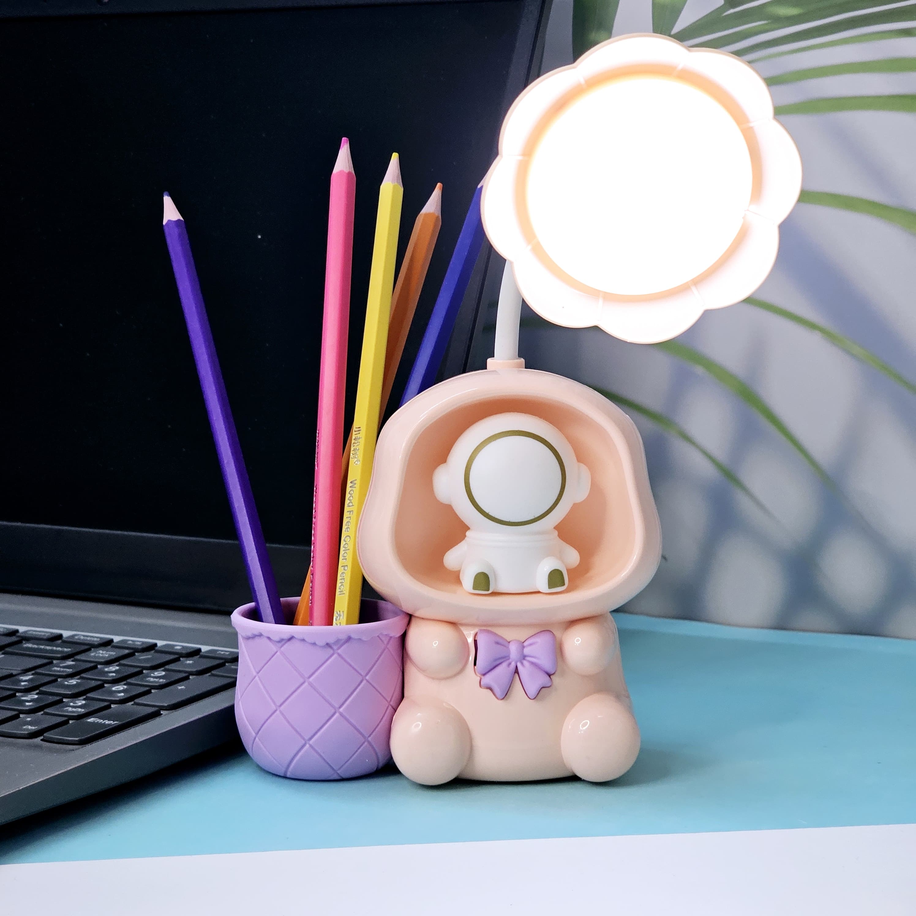Colorful Usmile Toys children's desk lamps, shaped like cute astronauts with light-up heads and built-in compartments for pencils, ideal for a child's study area or bedroom." www.usmile.toys
